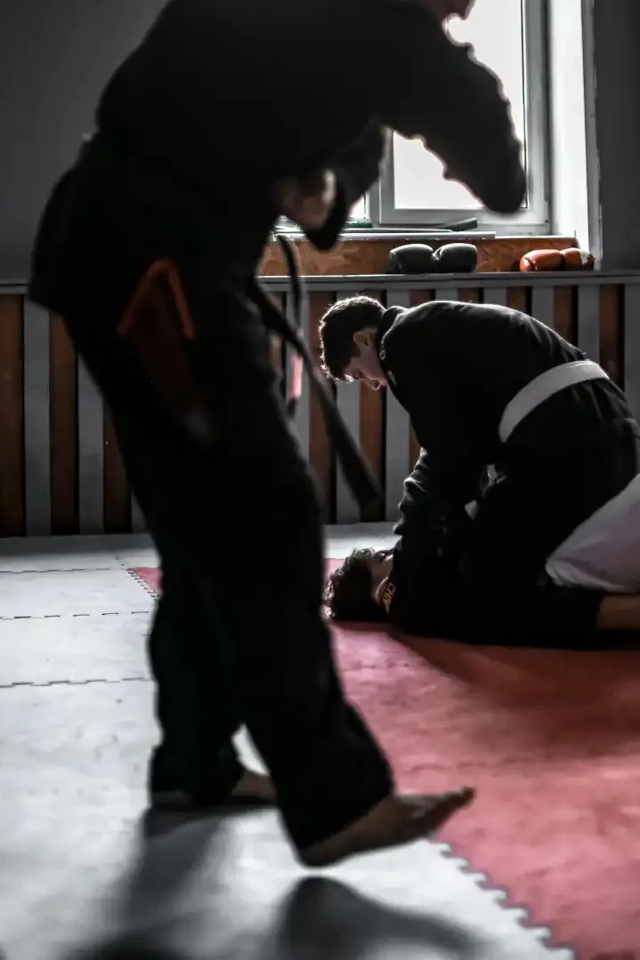 Zawodnicy BJJ trenują technikę w sali treningowej